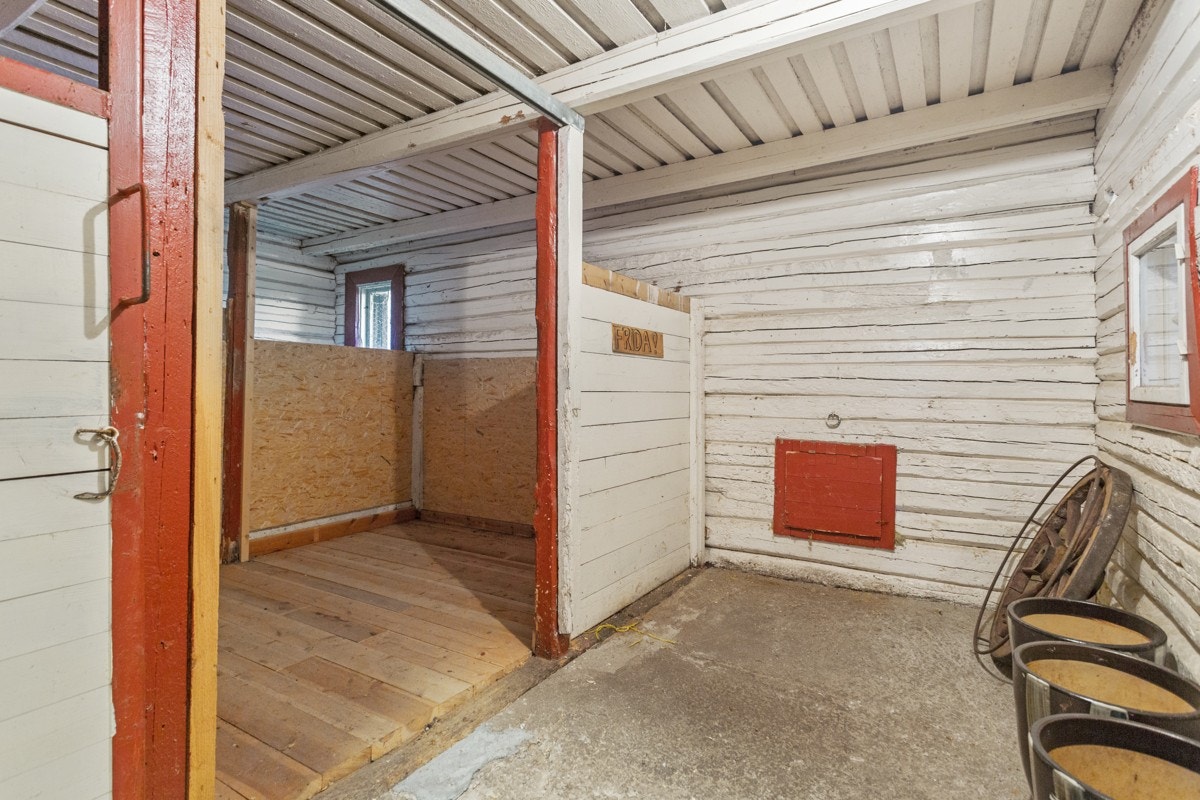 På låve er det en laftet stall med plass til hest. Galleribilde