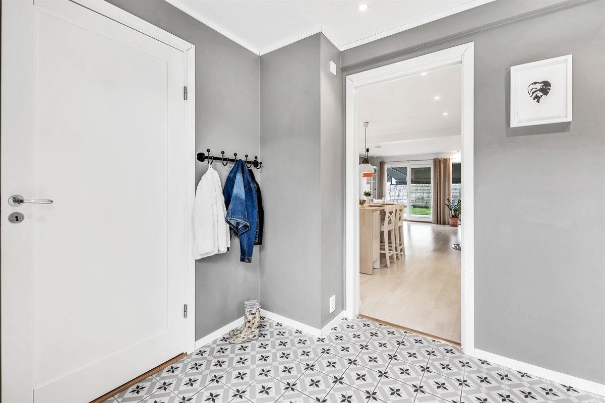 Entreen gir et godt førsteinntrykk med gråmalte veggflater, downlights i himling og lekre dekorfliser på gulv. Galleribilde