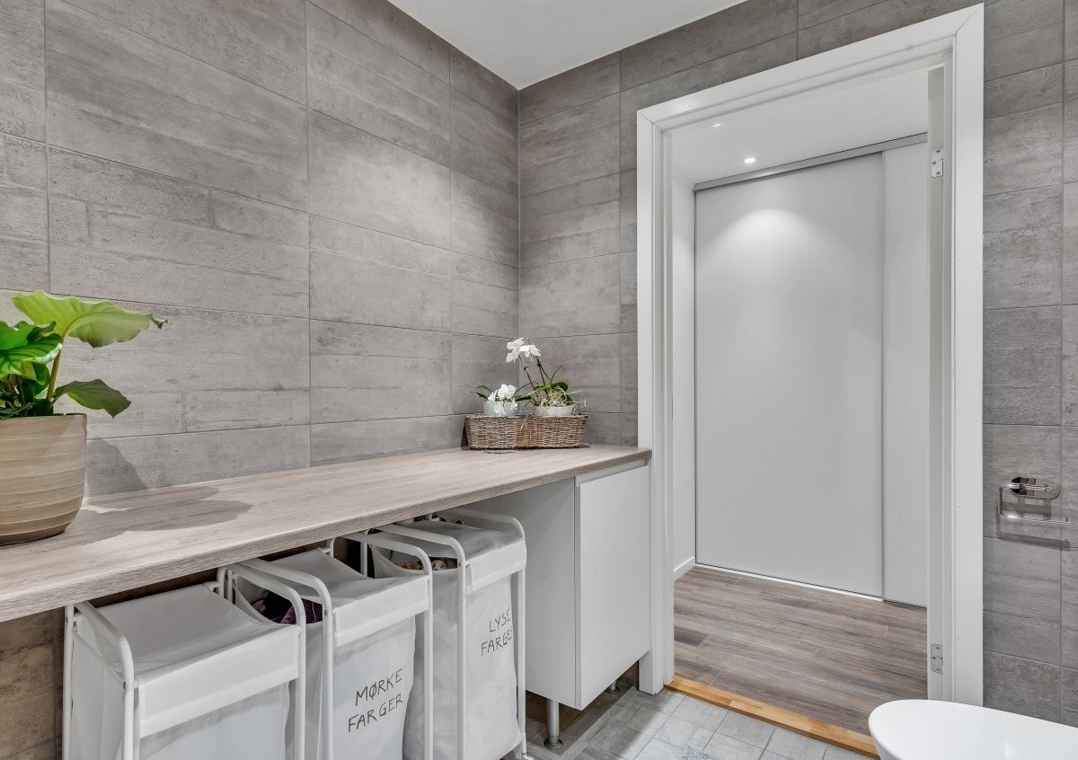 Det er opplegg for vaskemaskin og plass for tørketrommel i skapinnredning med tilknyttet benkeplate. Galleribilde