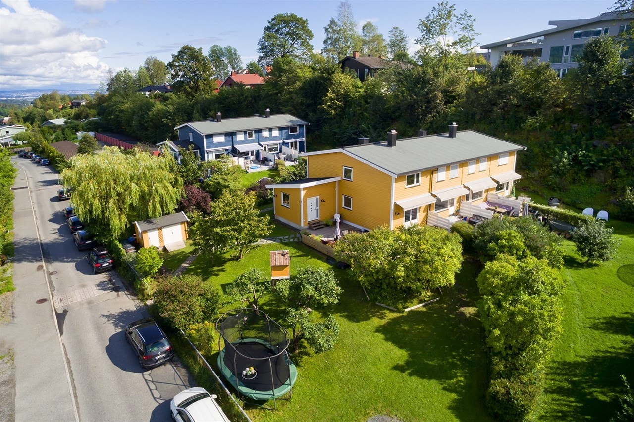 Romslig tomt med mye gress og busker. Det er laget trehytte til barn og satt opp stor lagringsbod på egen tomt. Galleribilde