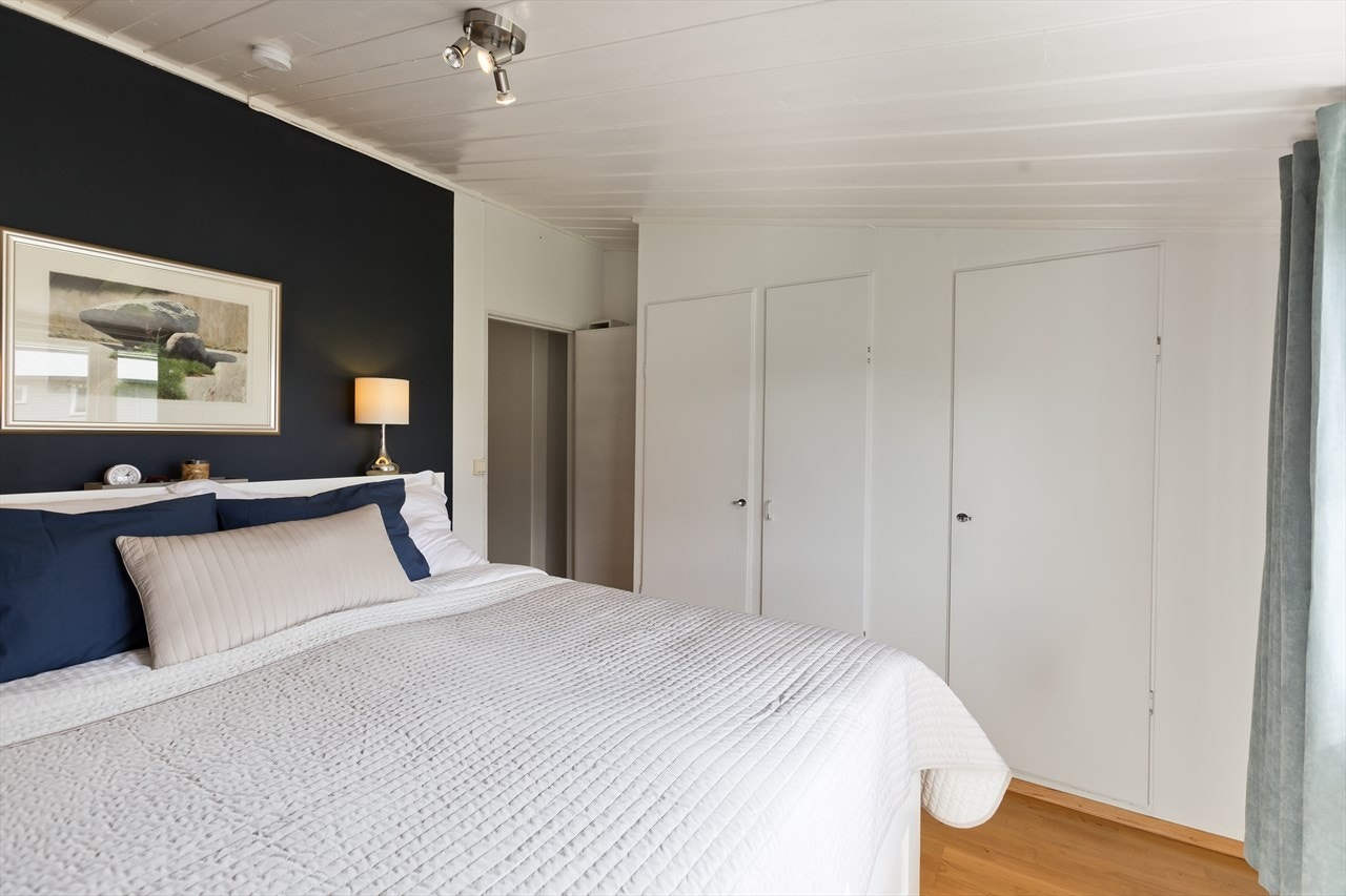 Store garderobeskap på begge sider av sengen på hovedsoverom. Galleribilde