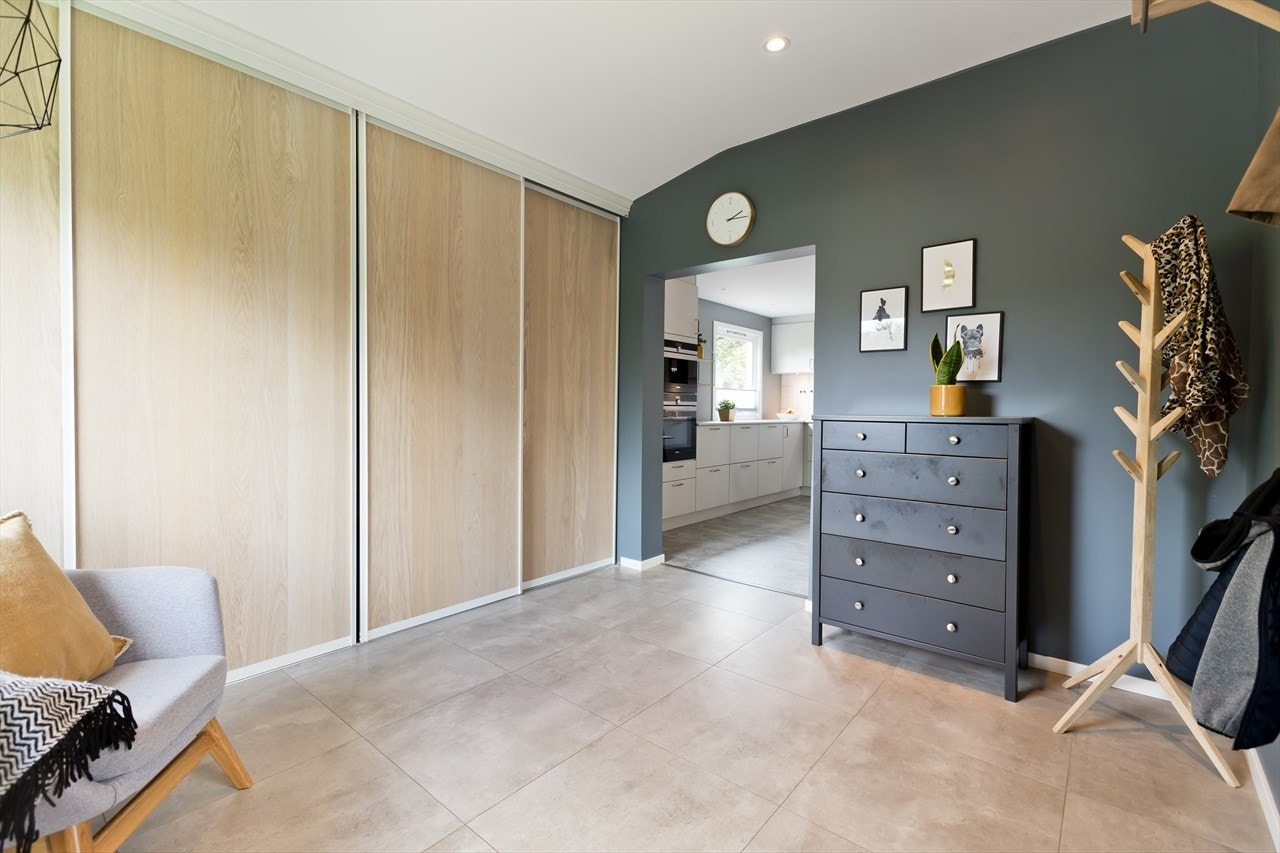 Stort garderobeskap med skyvedører og flere knagger og hyller for yttertøy og sko. Galleribilde