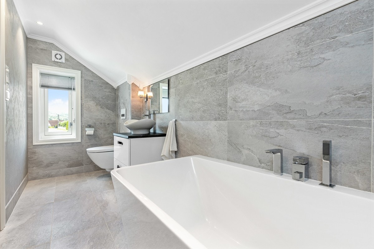 Det andre badet ligger i andre etasje og er tilknyttet hovedsoverommet. Badet har frittstående designbadekar med innebygget blandebatteri og dusjhåndtak. Galleribilde
