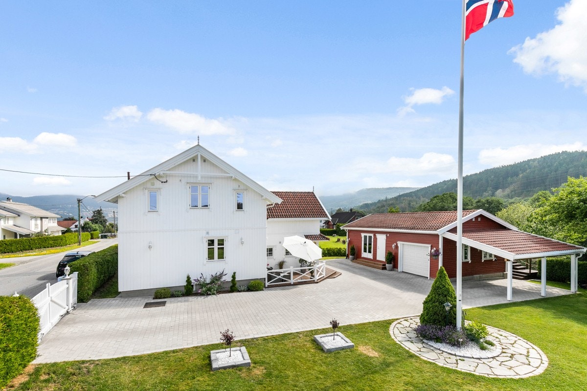 Blomsterbedet er pent steinsatt rundt flaggstangen. Galleribilde
