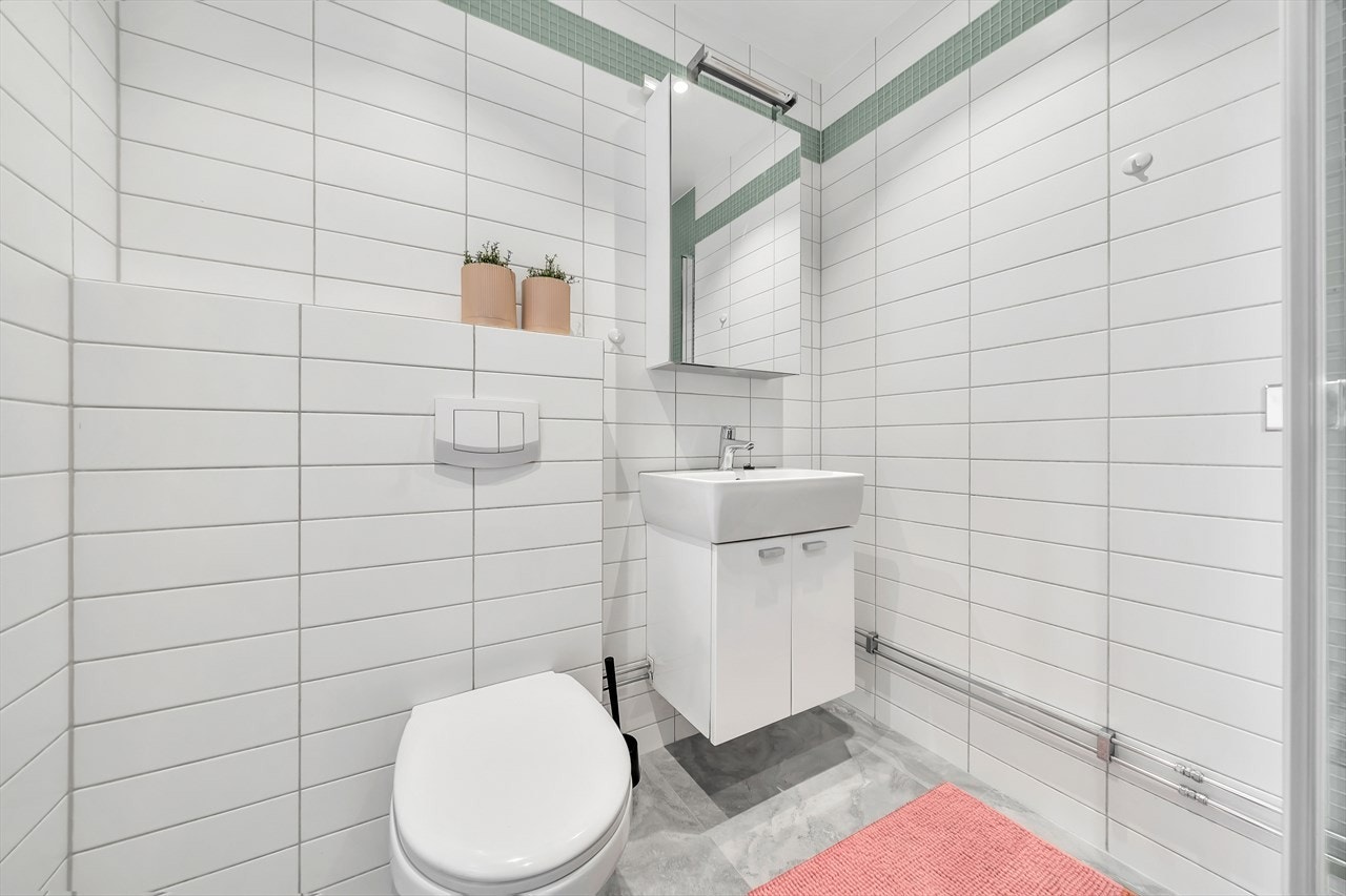 Vegghengt toalett, servant med skap og varmekabler i gulv. Galleribilde