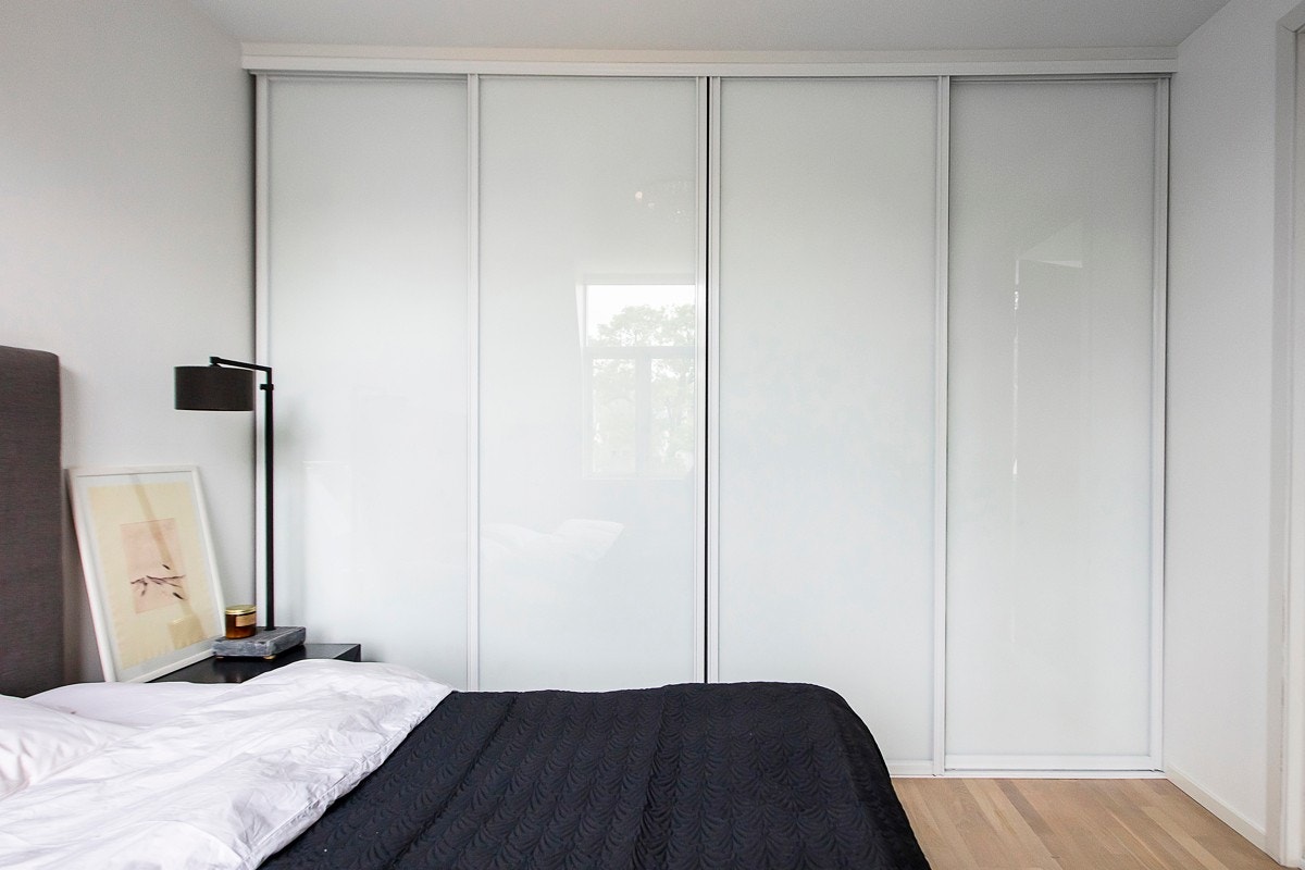 Langs den ene veggen er det satt opp skyvedørsgarderobe med hvite glassfronter. Galleribilde