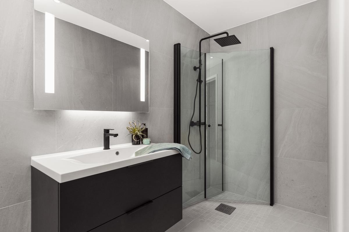 Badet i 2. etasje er romslig med lagringsrikt baderomsmøbel, flotte fliser på vegger og gulv i duse farger. Galleribilde