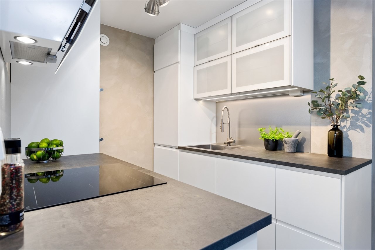 Lekkert kjøkken fra 2019 med hvite glatte fronter og pen benkeplate. Galleribilde