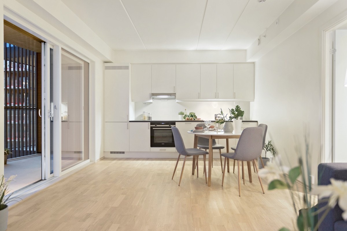 Stilsikkert kjøkken fra Sigdal i modellen Uno med hvite og glatte fronter. Laminat benkeplate i farge Smoked Quarterstone. Galleribilde