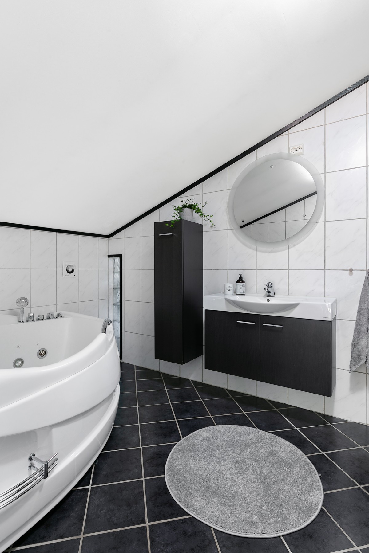 Bad er innredet med wc, servant med innredning og speil med belysning, samt hjørnebadekar