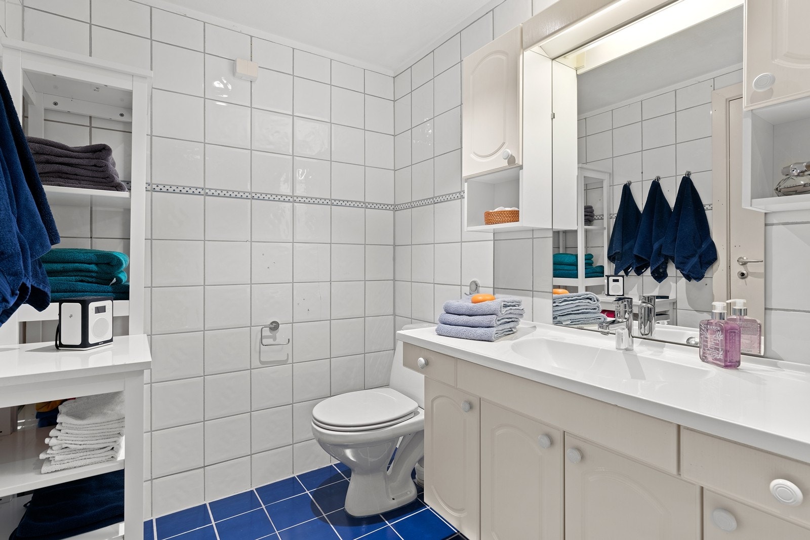 Flislagt bad som er innredet med heldekkende servant, underskap, speil, wc og badekar med dusjmulighet. Downlights i badet, og varme i gulv. Galleribilde