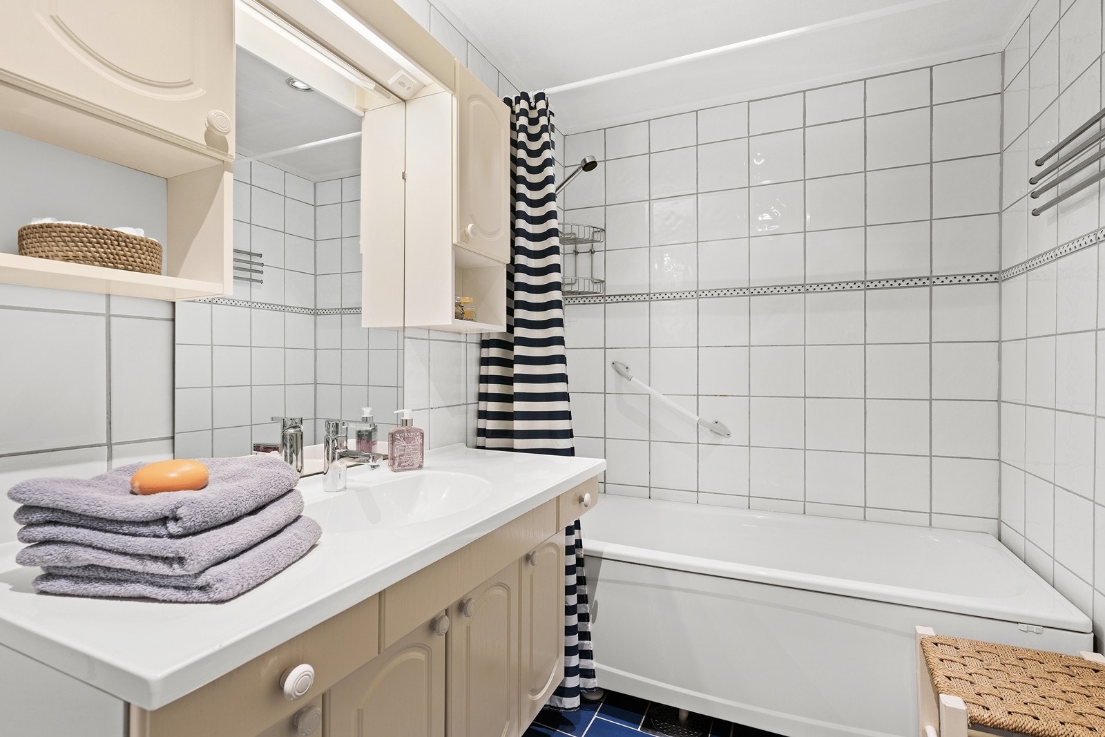 Flislagt bad som er innredet med heldekkende servant, underskap, speil, wc og badekar med dusjmulighet. Downlights i badet, og varme i gulv. Galleribilde