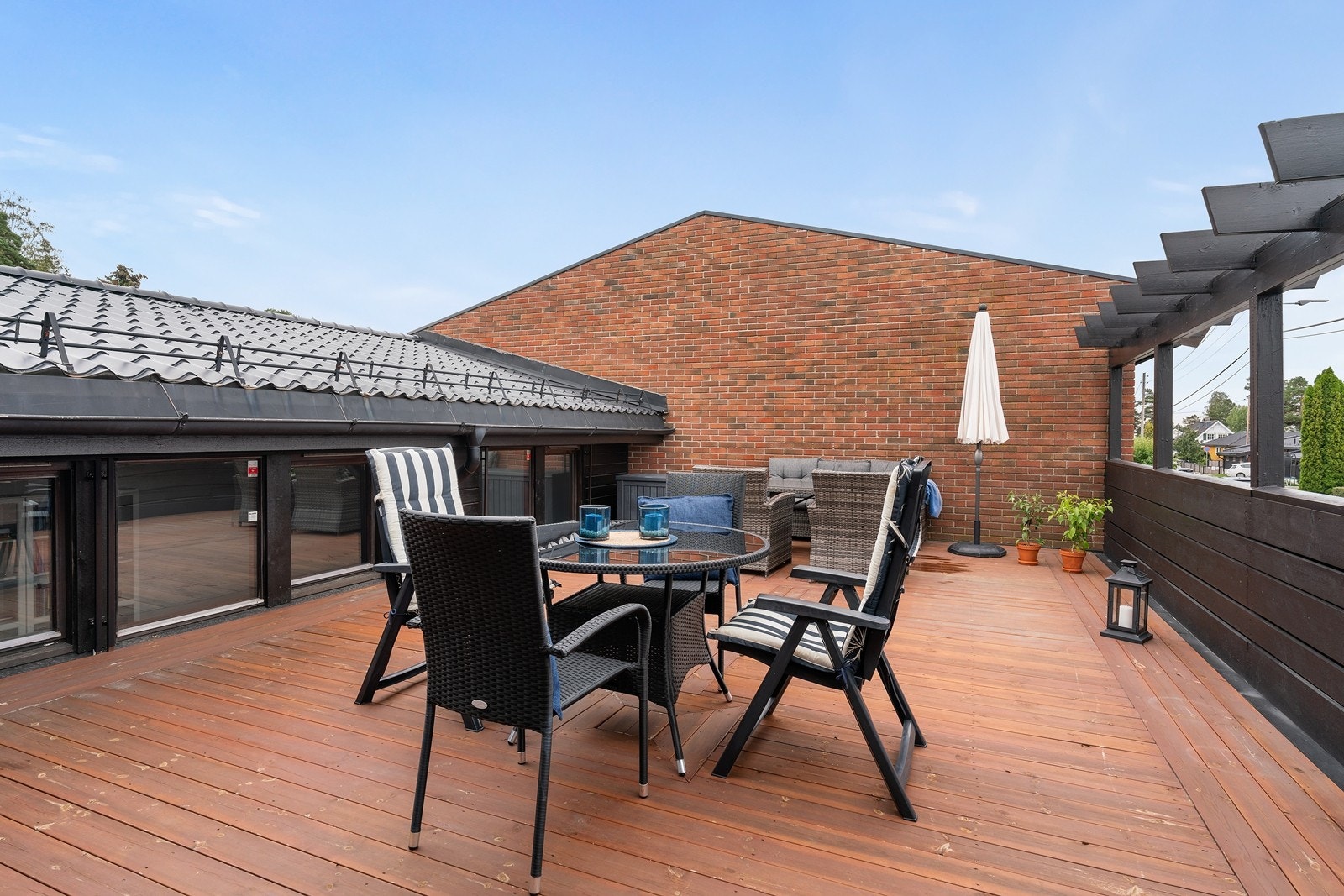 Stor, solrik og skjermet atrium på ca. 40 kvm. som fungerer som en flott og skjermet utvidelse av stuen på sommerstid. Her er det god plass til både lounge, sittegrupper og grill. Alt som trengs for å nyte sommerhalvåret. Motorisert markise ved terrasse Galleribilde