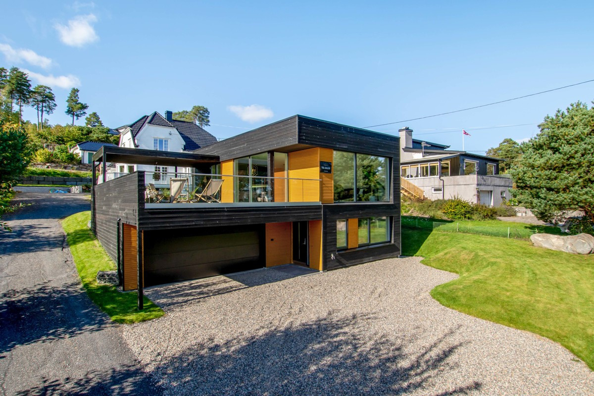 Et steinkast fra sjøen ligger et nybygget, arkitekttegnet funkishus.