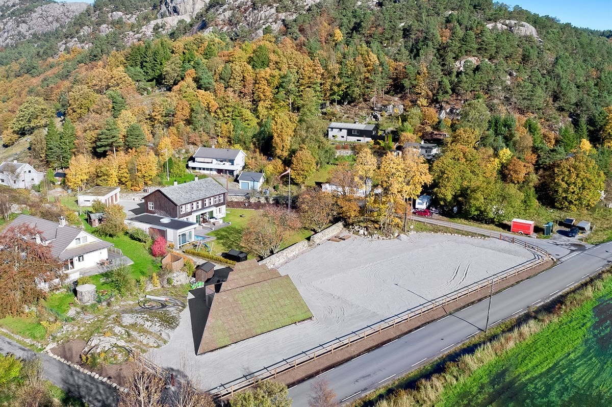 Ridebanen ligger i tilknytning til hagen rundt boligen, adskilt av et nydelig steingjerde. Galleribilde