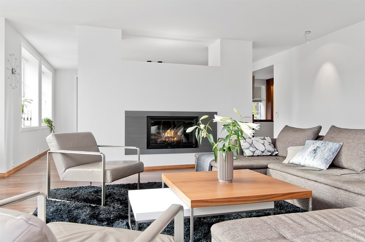 En delvegg med en lekker peis med innsats skiller rommene. Galleribilde