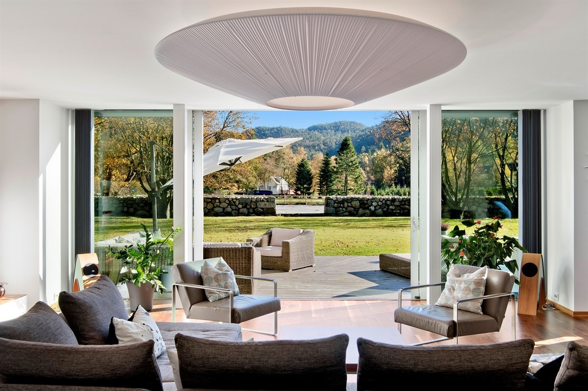 Stuen er lys og luftig - et nydelig rom med store, heldekkende vinduer og skyvedører i glass ut mot terrassen. Galleribilde