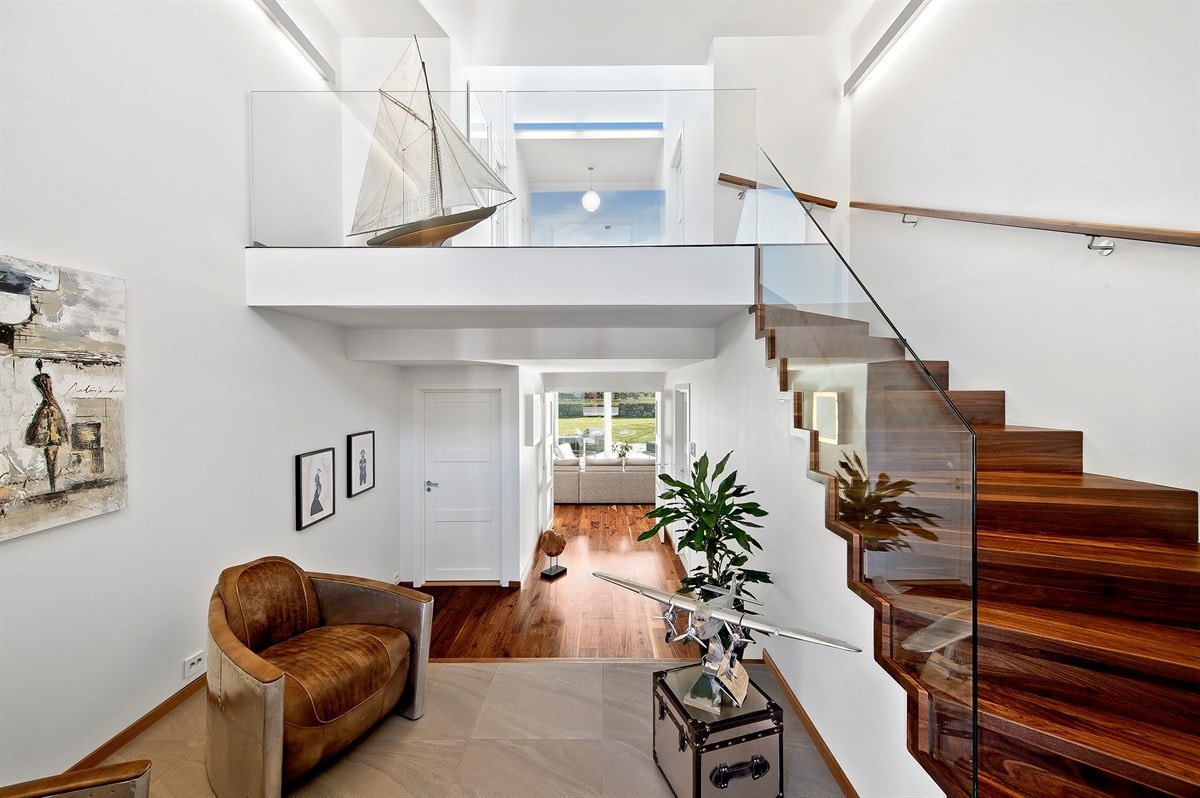 I andre etasje er det glassrekkverk ned, og i tillegg bidrar et stort vindu til en luftig og fin romfølelse. Galleribilde