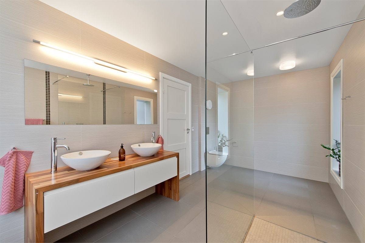 Det ene badet ligger i mastersuiten i første etasje og har store, italienske fliser på gulv og vegger. Galleribilde