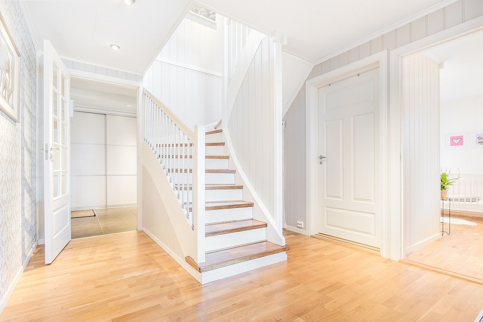 Hall med parkett på gulv og downlights i himling, med direkte utgang til terrasse. Galleribilde