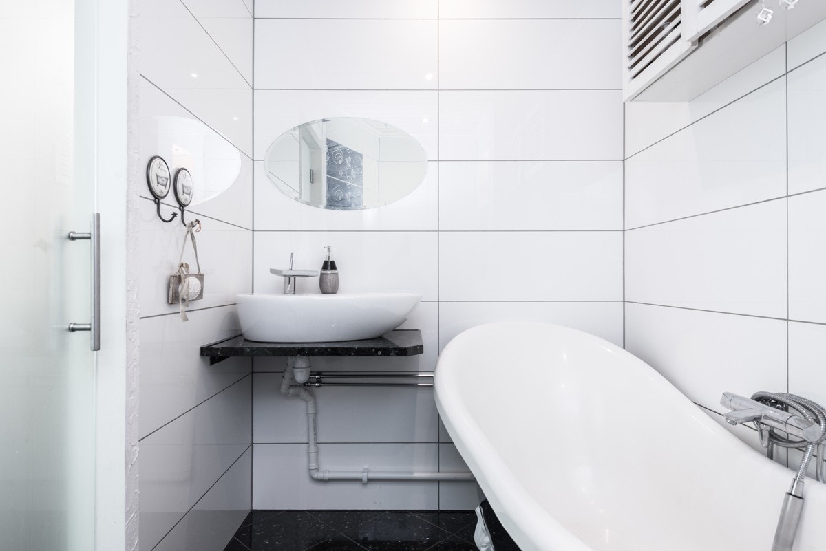 Badet i 1. etasje er helfliset med lakkert panel og spotter i himlingen. Nytt i 2008. Innredet med badekar, vegghengt toalett, servant og nisje i vegg med hyller. Avtrekk fra balansert ventilasjonsanlegg. Galleribilde