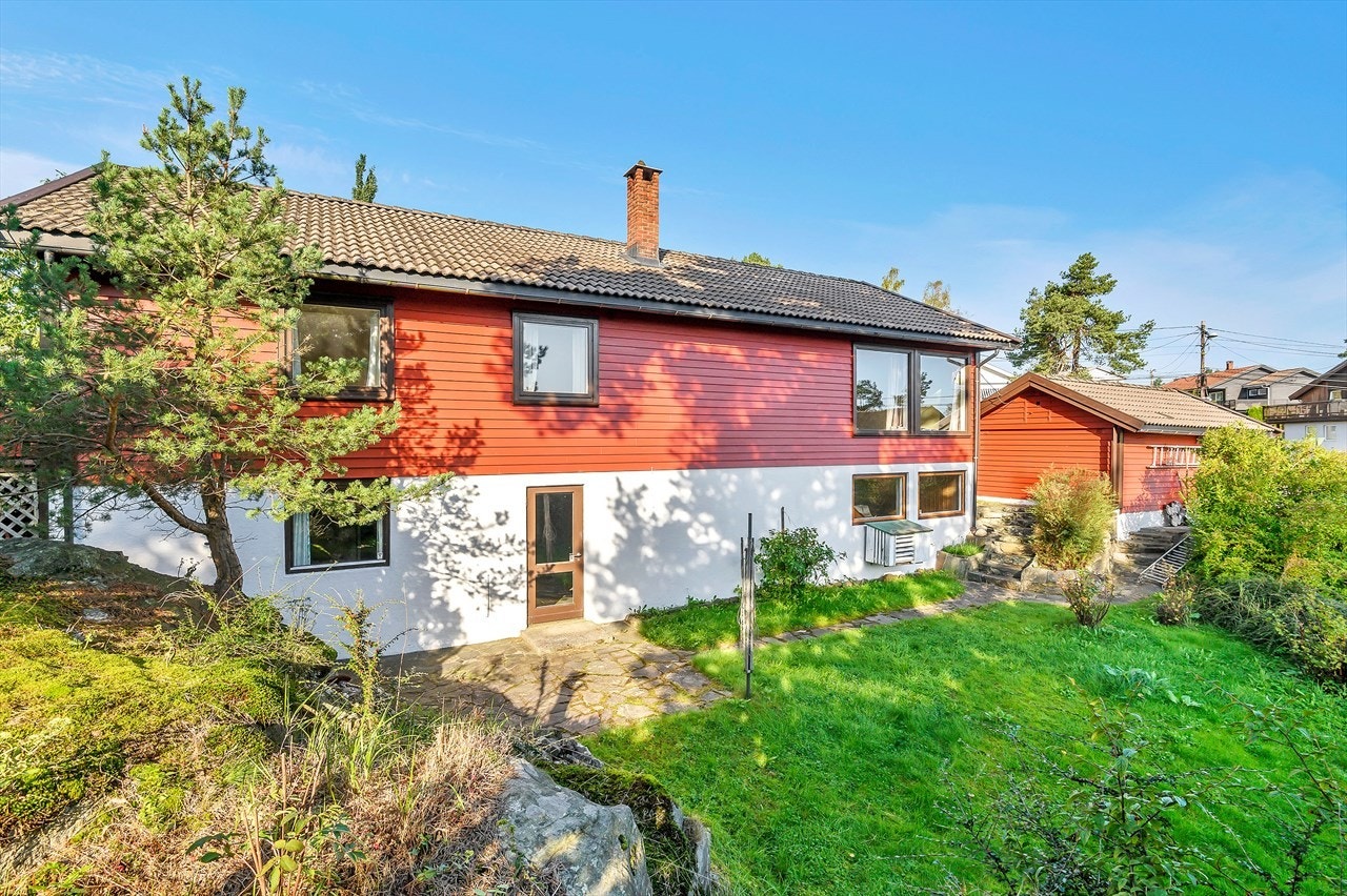 Tomten er opparbeidet med plen, hekk, busker, trær og frukttrær. Asfaltert innkjørsel. Solrike, hyggelige uteplasser. Galleribilde