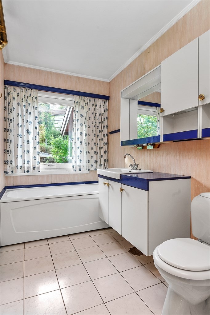 Bad med WC, servantinnredning og badekar. Galleribilde