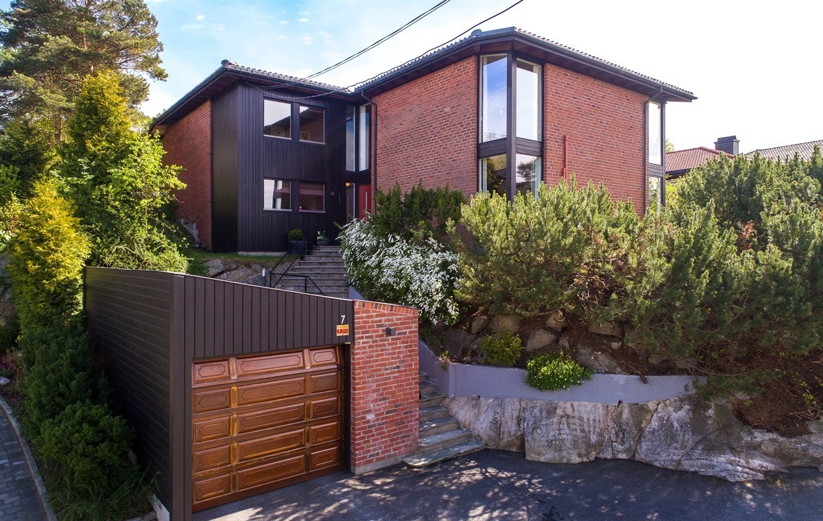 Fasade mot vest med garasje og trapp til inngangspartiet. Galleribilde