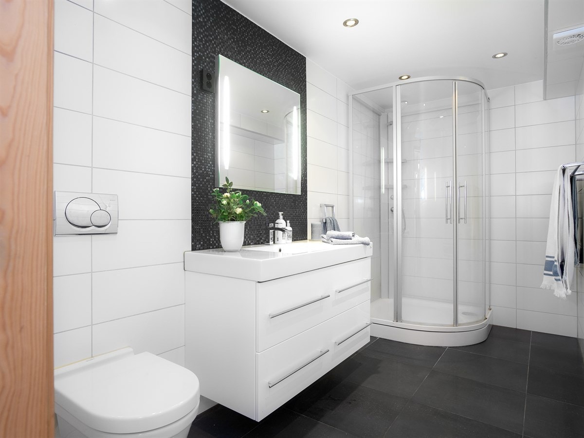 Badet i underetasje med vegghengt wc, dusjkabinett og servantskap. Galleribilde