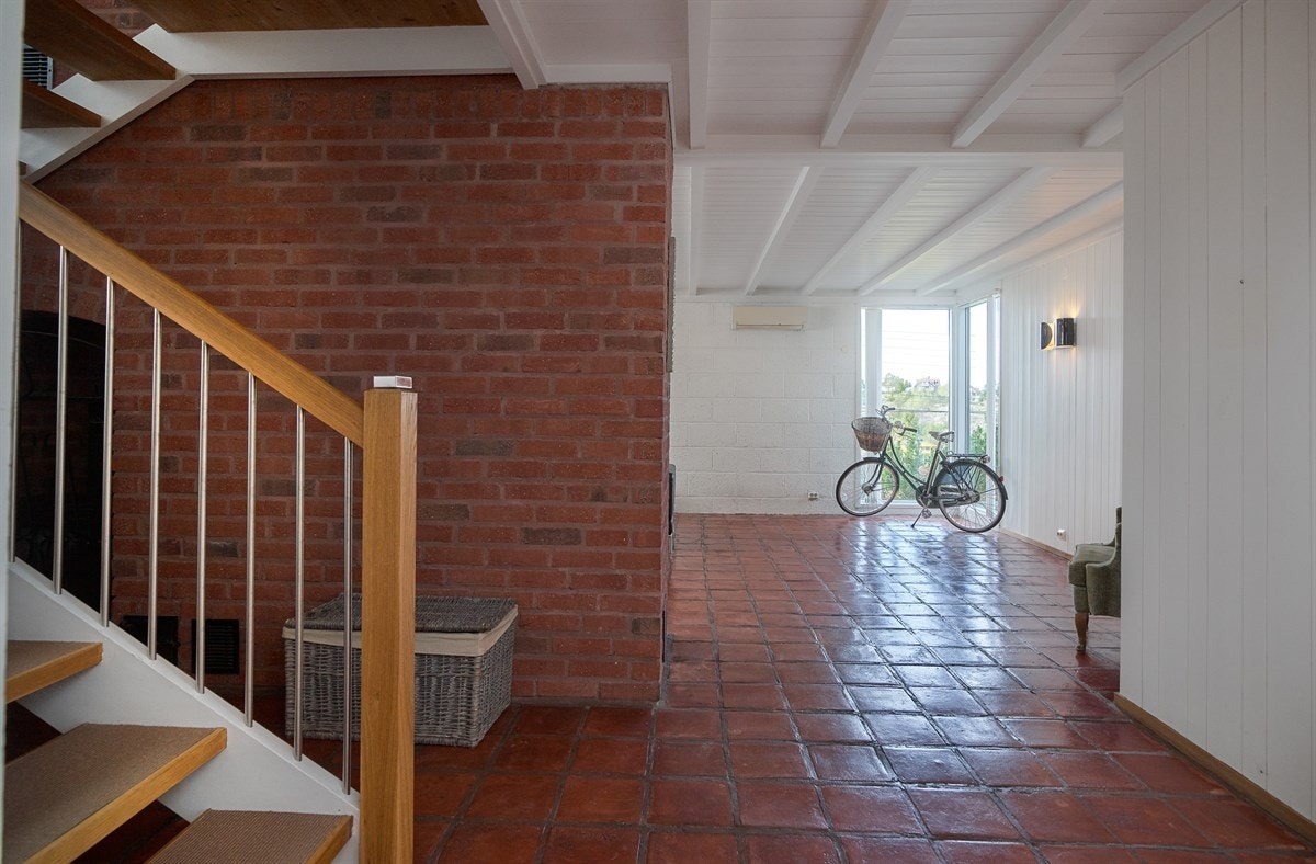 Hallen leder inn til en stor peisestue i underetasjen og trappen opp til første etasje. Galleribilde