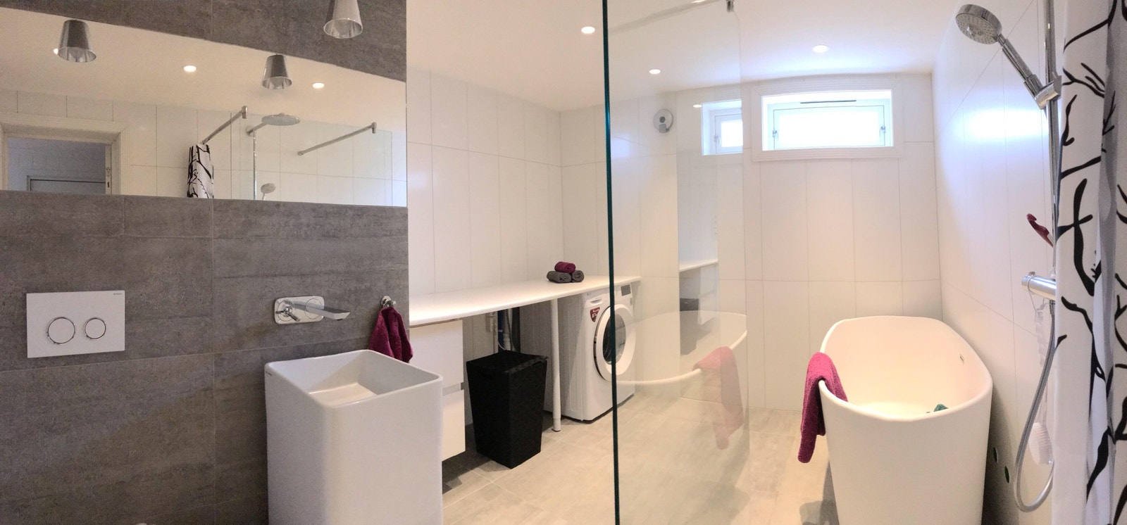 stort bad med badekar og vaskemaskin Galleribilde