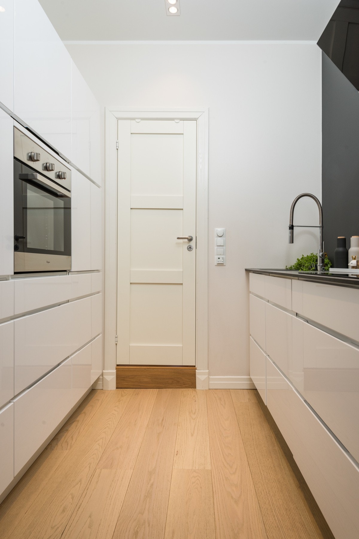 Lekkert innholdsrikt kjøkken med takhøye skap og integrerte hvitevarer Galleribilde