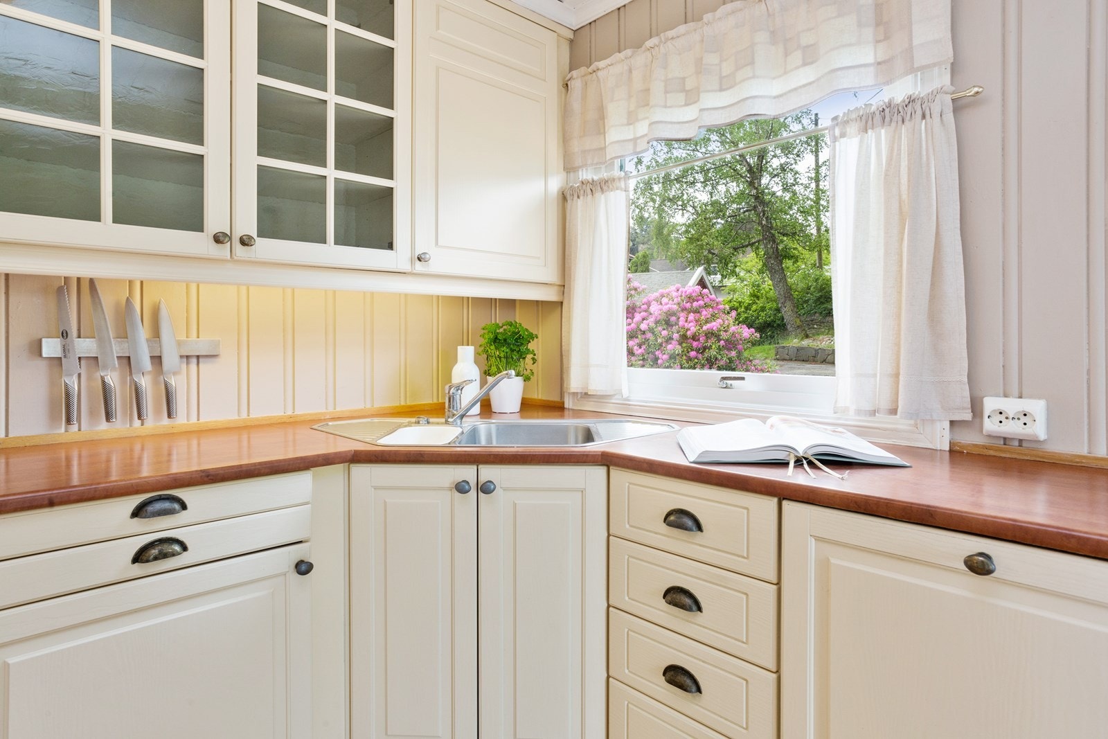 Strai kjøkken med stort vindu og godt med skap -og benkeplass Galleribilde