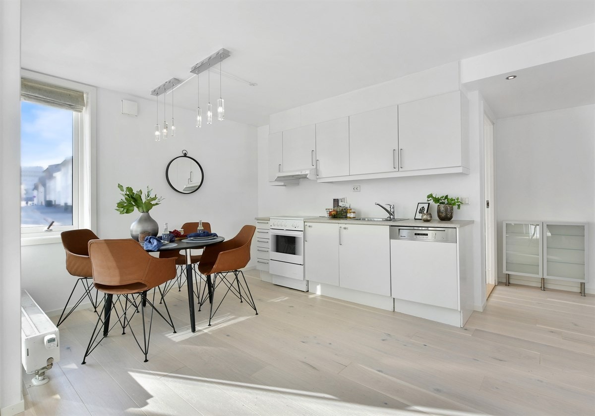 Kjøkkeninnredningen er pen med hvite, glatte fronter og laminert benkeplate med nedfelt dobbel oppvaskkum. Over benken er det belysning, og over kokesonen er det montert en avtrekksvifte. Av hvitevarer har kjøkkenet komfyr og integrert oppvaskmaskin. Galleribilde