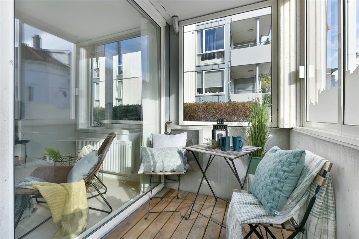 Fra stuen er det utgang til en herlig, innglasset balkong på ca. 4,1 kvm, med terrassebord i trevirke. vinduene kan skyves til side slik at solen og lyset slipper inn. Galleribilde