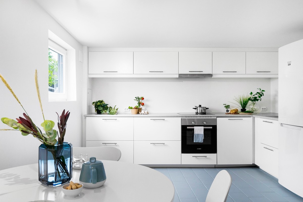 Hvit kjøkkeninnredning fra ikea med glatte fronter og integrerte hvitevarer. Galleribilde