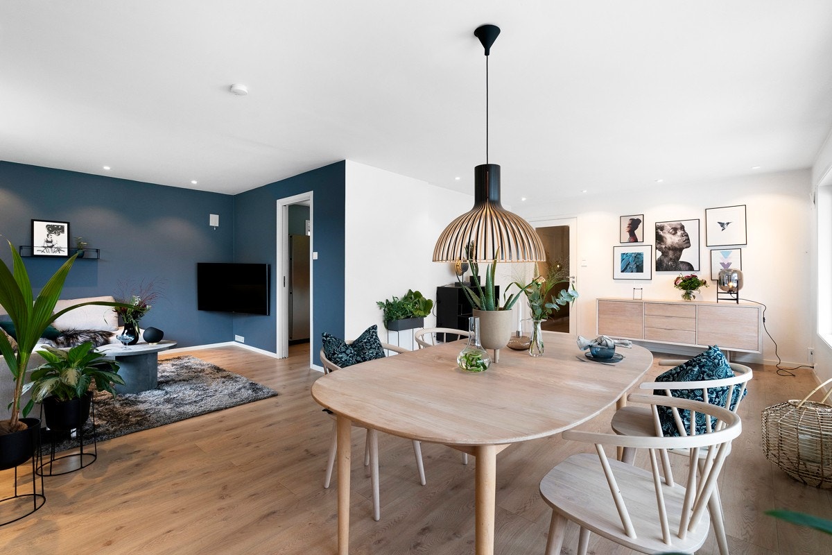 Veggene er holdt i en lys farge, mens tv-stue delen av rommet har fått en mørkere blåtone. Galleribilde