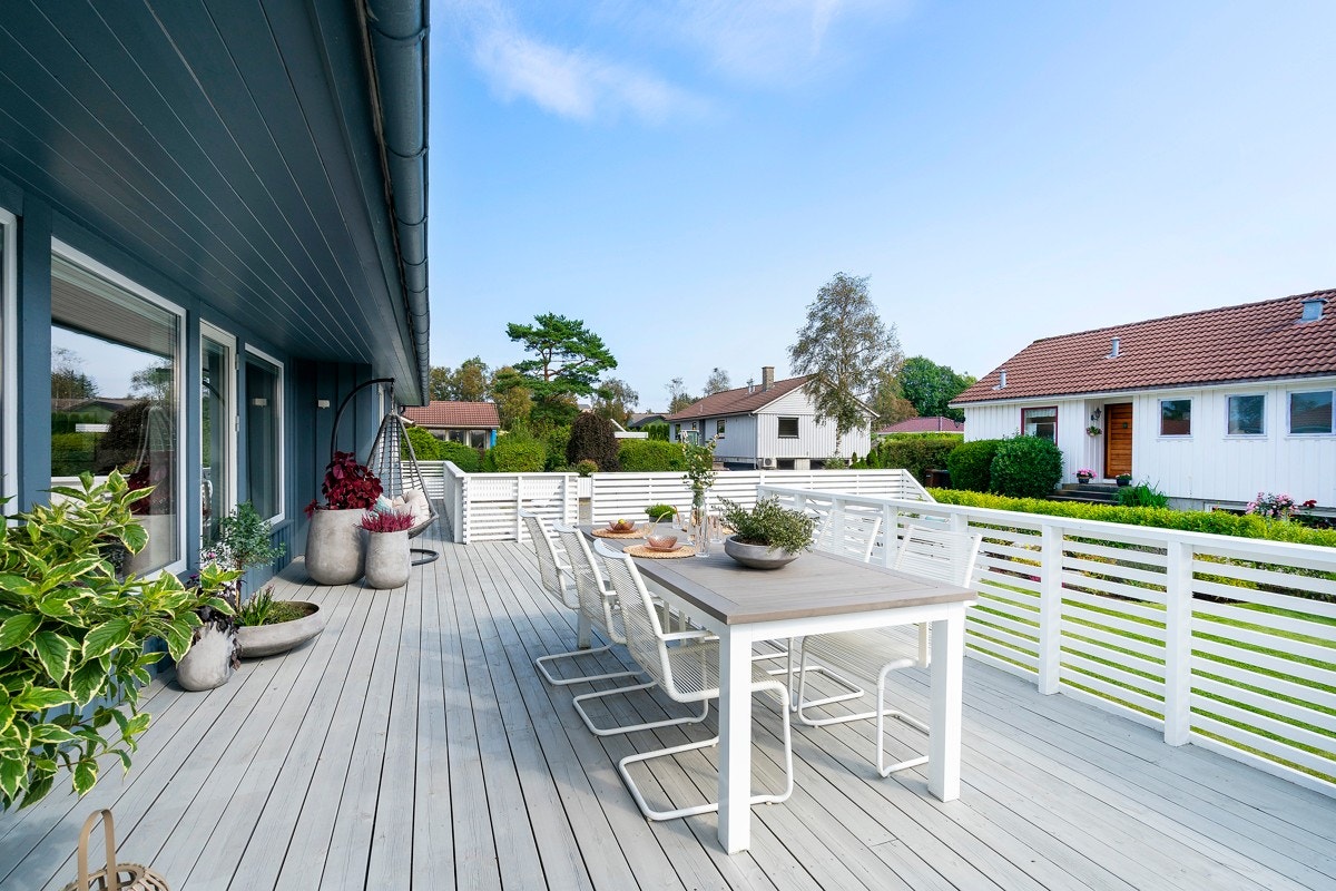 God plass til spisebord og flere gjester på en fin sommersdag. Galleribilde