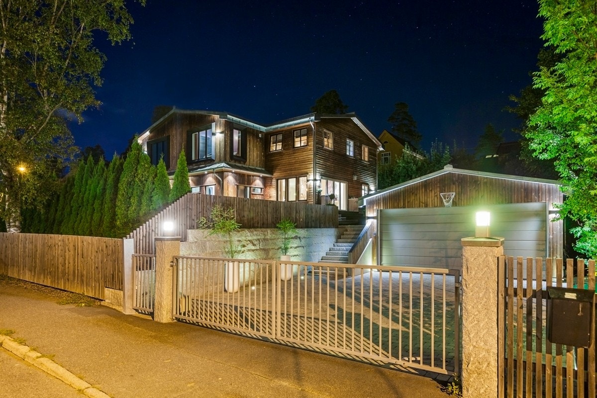 Innkjørsel med portstolper i granitt og motorstyrte stålporter. Galleribilde