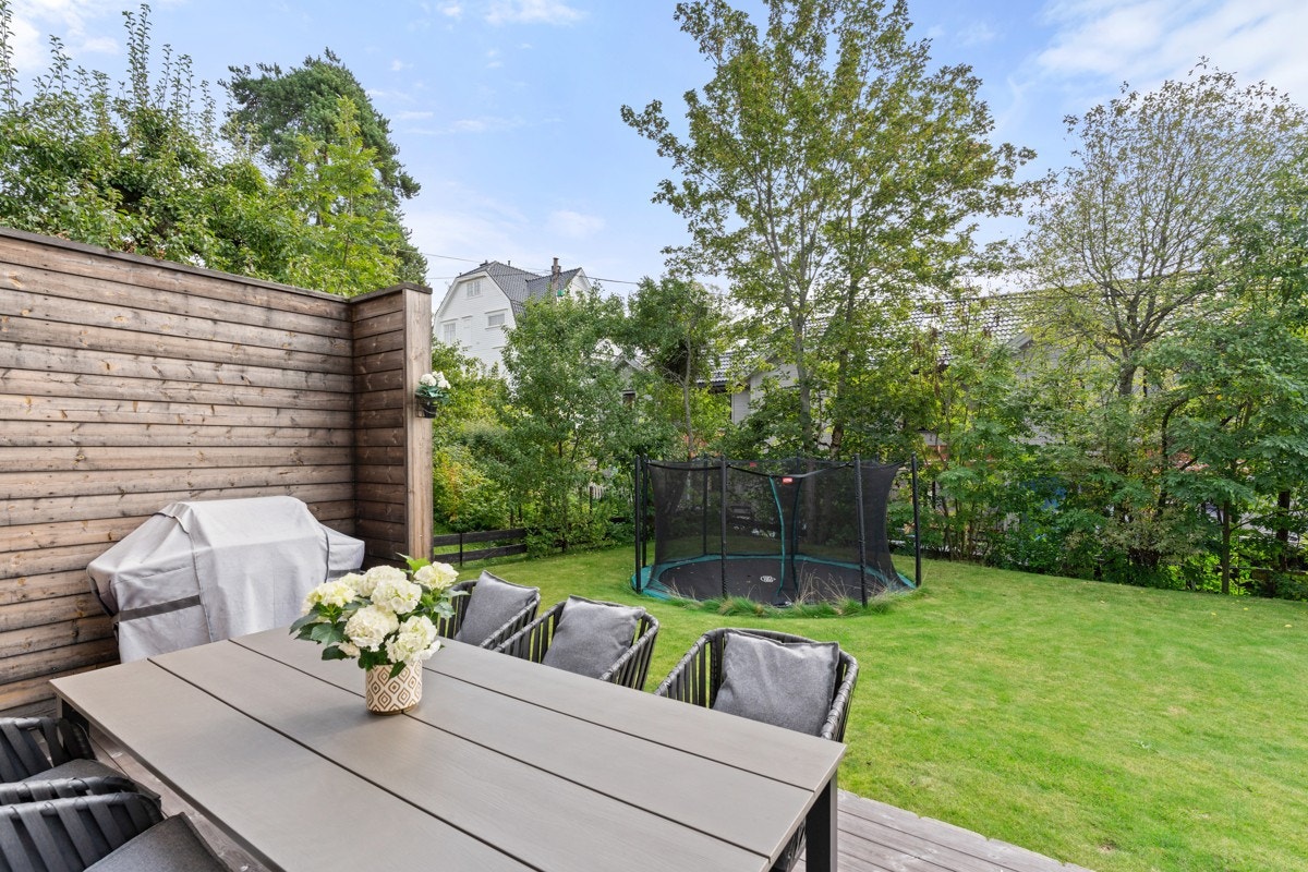 Lettstelt, flat hage med nedgravd trampoline. Galleribilde