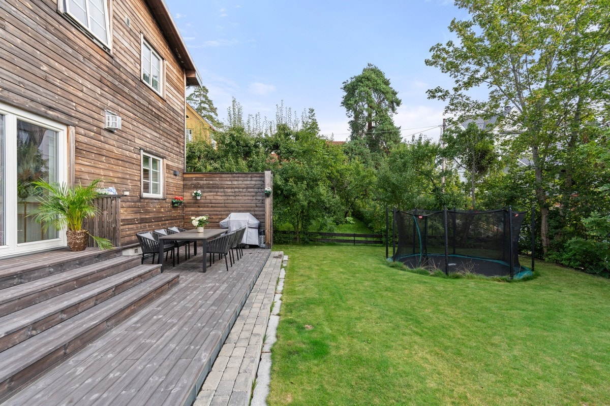 Lettstelt, flat hage med nedgravd trampoline. Galleribilde