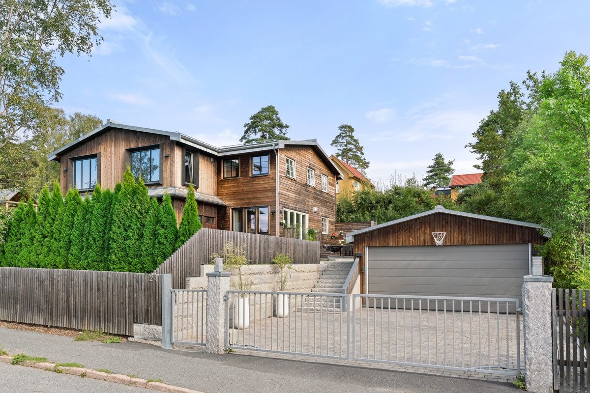 Forstøtningsmur og utvendig trapp i granitt fra gårdsplass opp til hage. Galleribilde