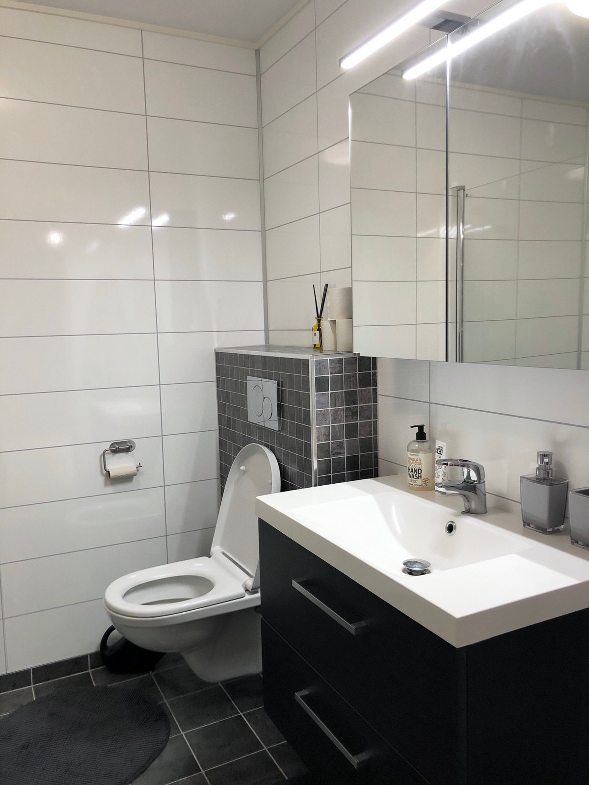 Moderne og lyst bad med gulvvarme, store fliser og spotbelysning. Galleribilde