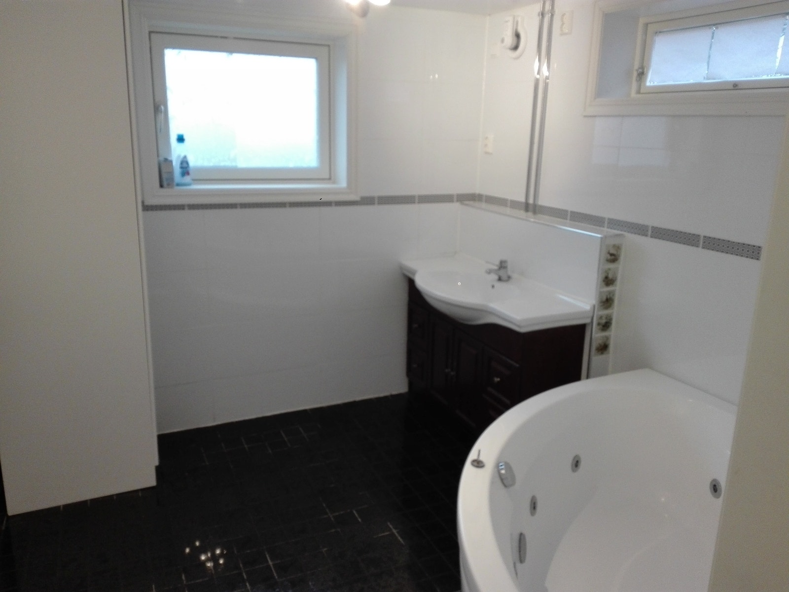 Badet sett fra døren.Svarte granittfliser på gulvet,boblebad og godt med lys.(rømningsvindu). Galleribilde