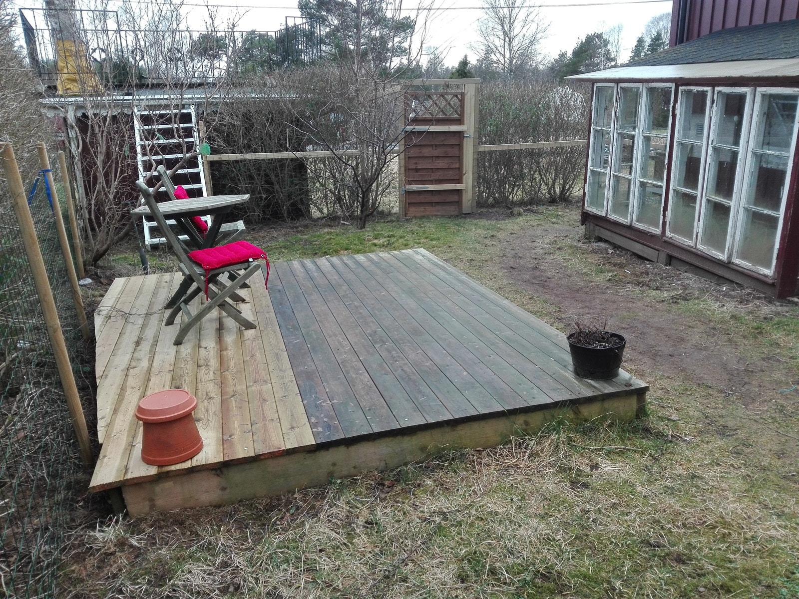 Uteområdet sett fra siden av porten.I enden av glassveggen(som fungerer som ett enkelt drivhus/beskyttelse mot vind og regn,er trappen ned til leiligheten.(vinduene trengs kitt og maling til våren)😉 Galleribilde