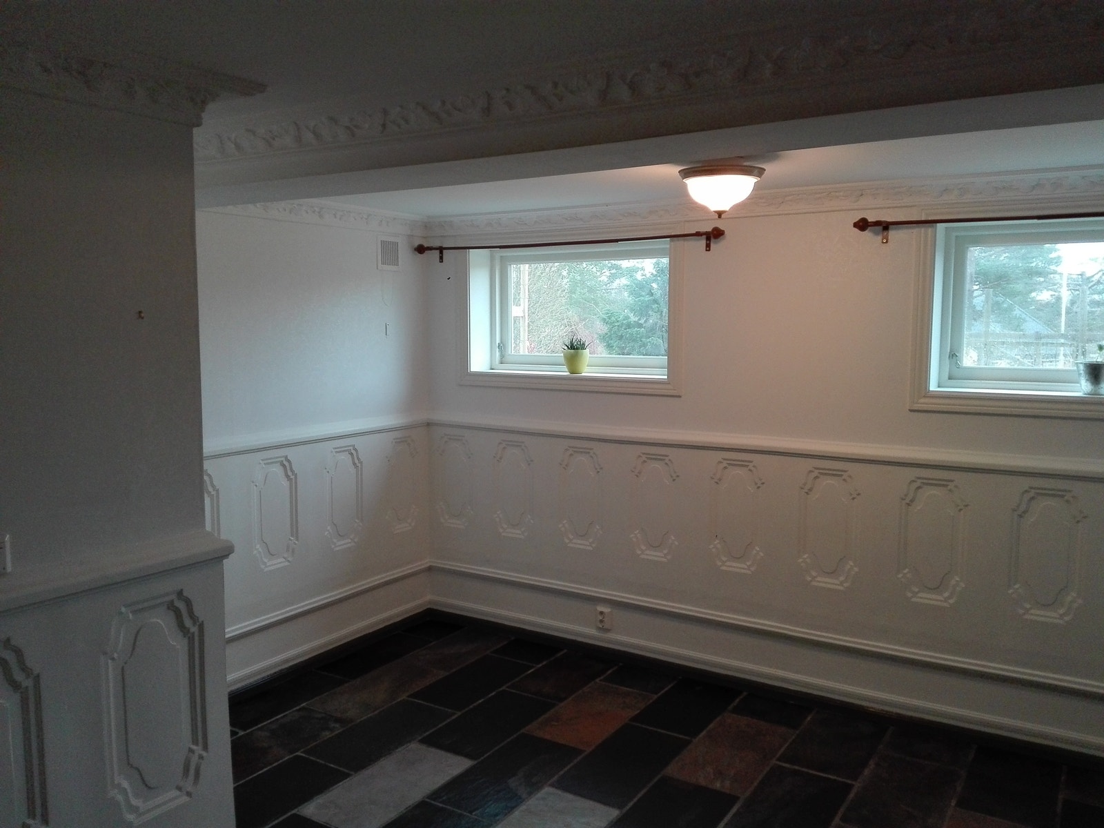 Stua sett fra skyvedør.Veggspeil i gips som brystning.Hvit tapet,med svakt klassisk mønster på veggene.Skifergulv med varmekabler.Vinduene vender mot hagen og vest.Mye dagslys. Galleribilde
