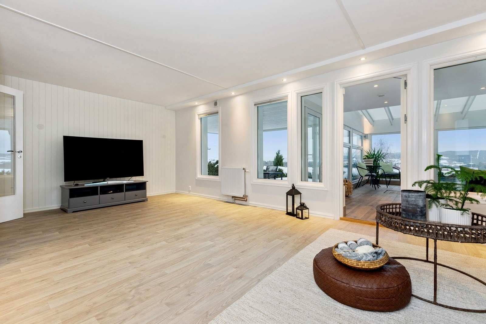 Stuen er luftig med vinduer i yttervegg og til bassengrommet, samt med lyse, pene overflater Galleribilde