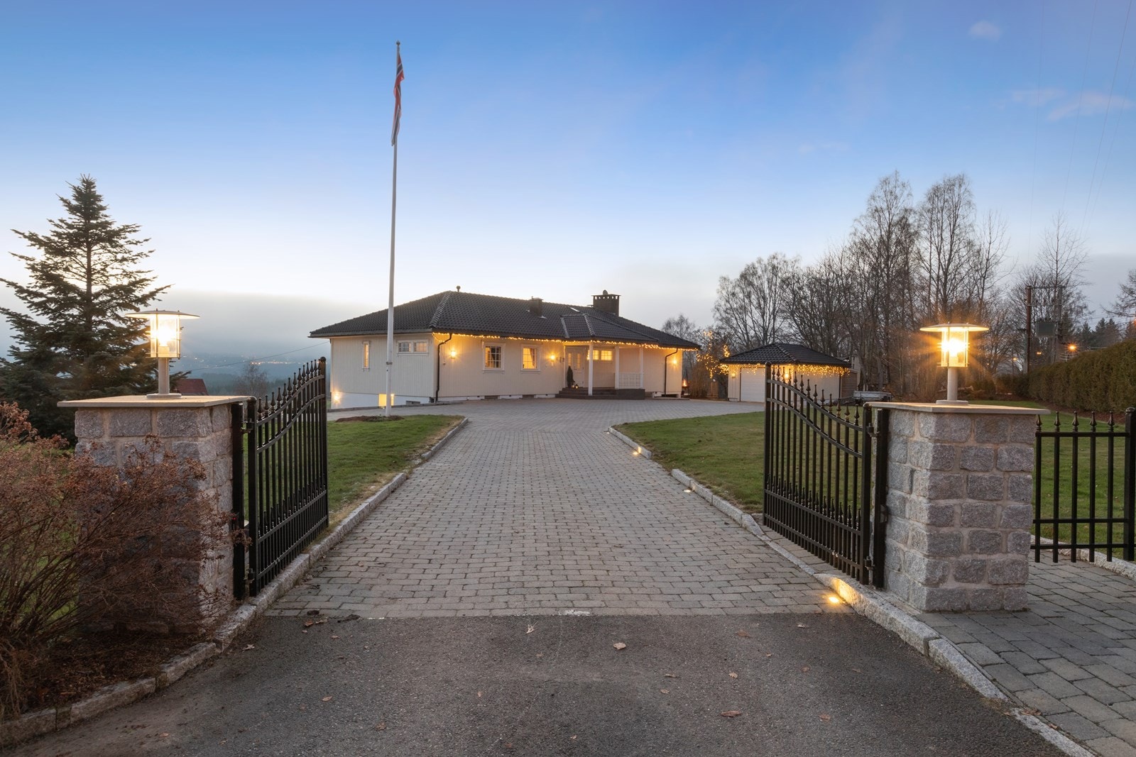 Innkjøring foran huset via flotte smijernsporter, ca 600 kvm anlagt med belegningsstein. Galleribilde