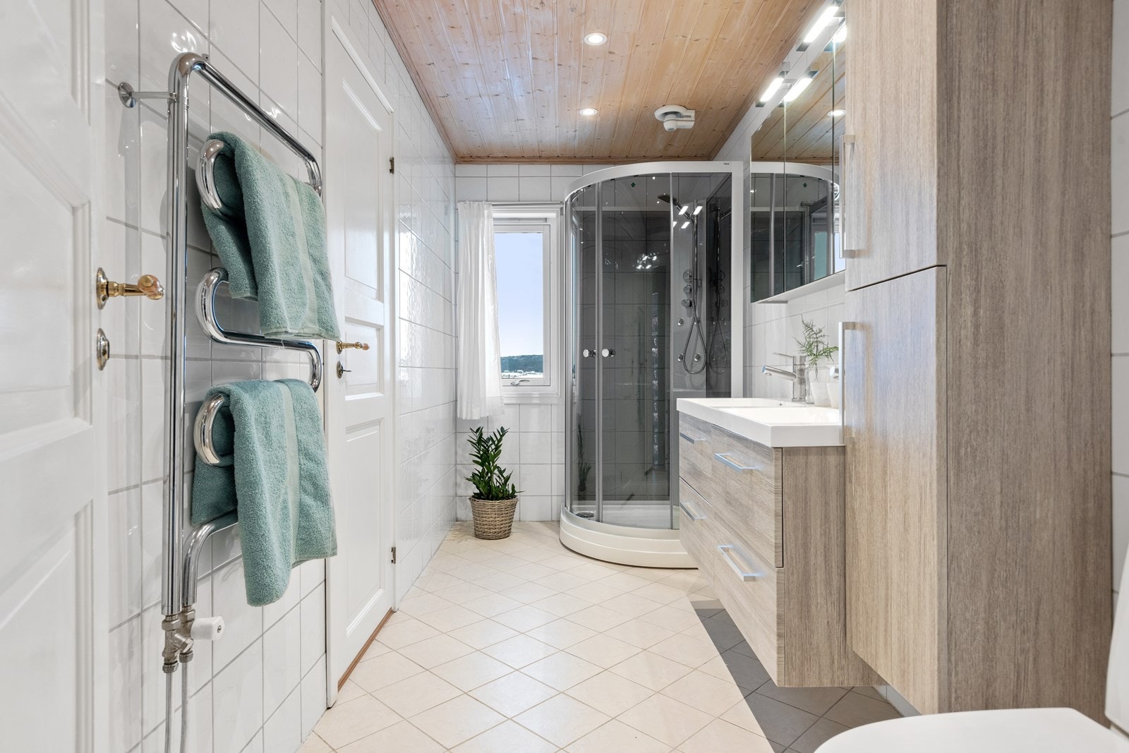 Badet i første etasje har lyse flissatte overflater. Galleribilde