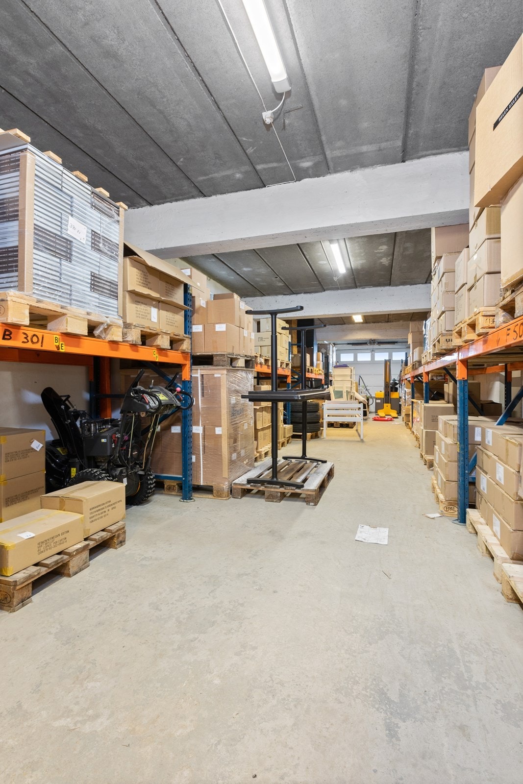 Driftsbygning/låve er innredet med store lagerlokaler. Her vises lager i underetasjen. Galleribilde